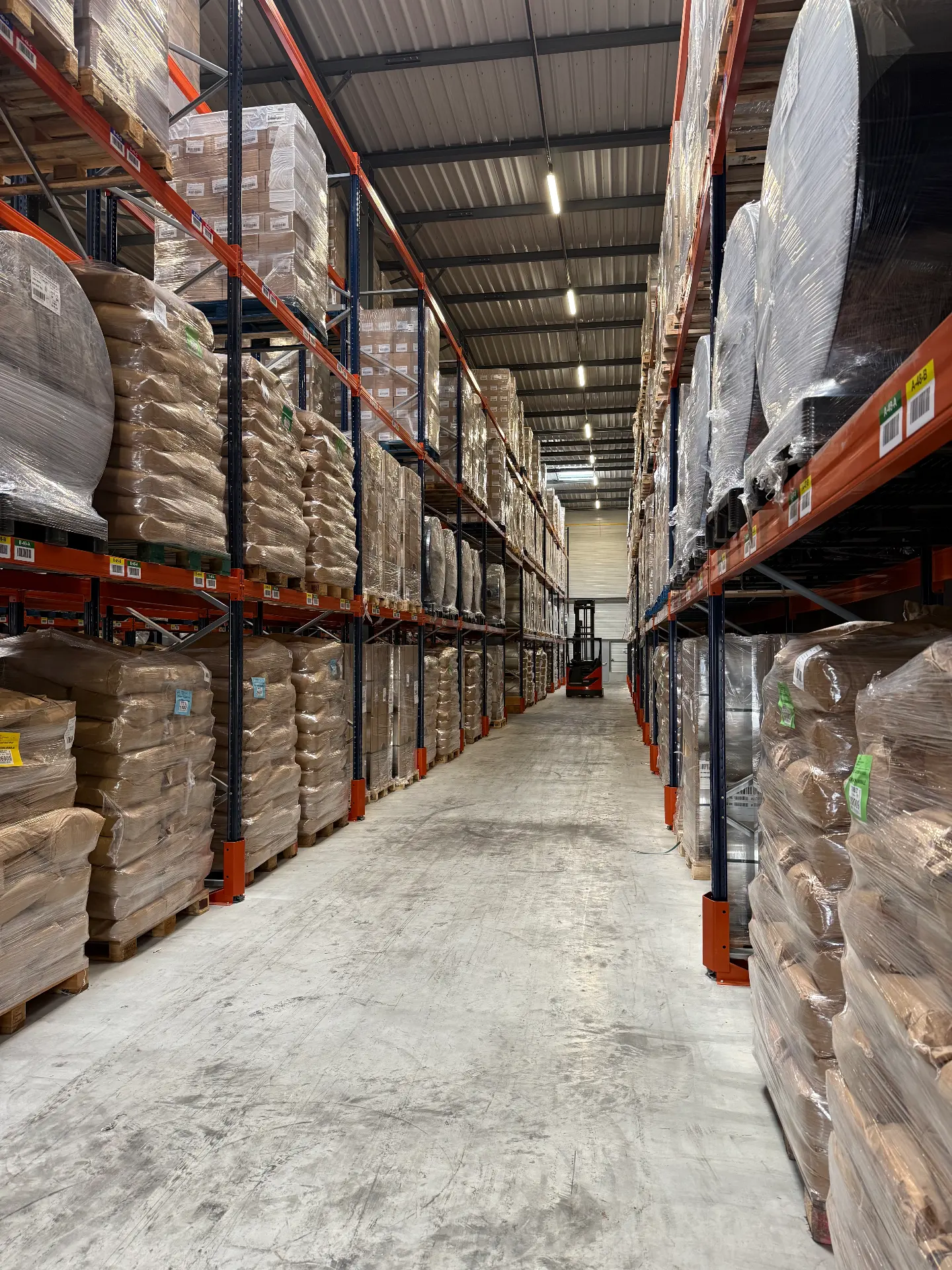 Palettes de sacs et de bobines stockées sur plusieurs niveaux de racks